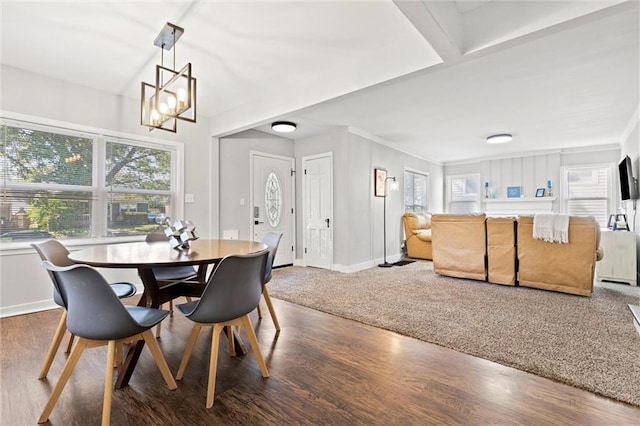 dining space featuring wood-type flooring, an inviting chandelier, and ornamental molding