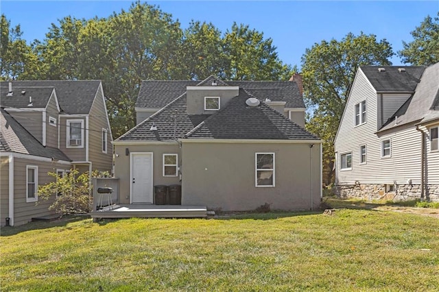 back of property with a lawn and a wooden deck