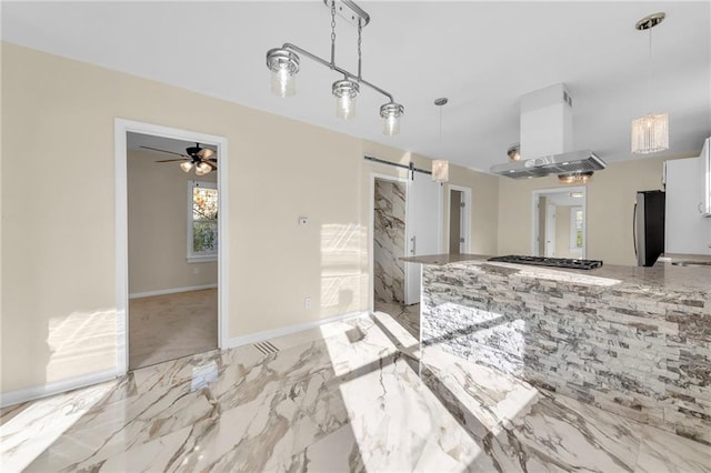 kitchen featuring white cabinets, a barn door, decorative light fixtures, island range hood, and stainless steel appliances