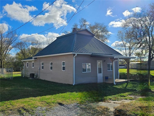 view of side of home with cooling unit and a lawn