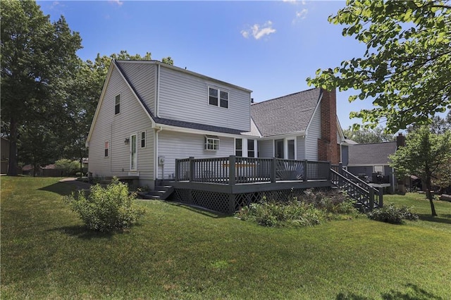 rear view of property with roof with shingles, a lawn, and a wooden deck