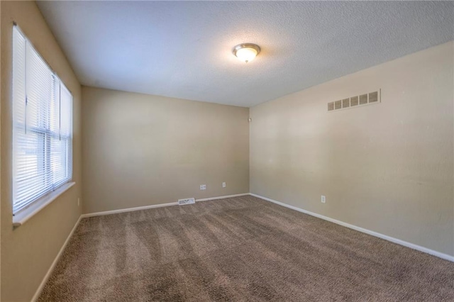 carpeted spare room featuring a textured ceiling