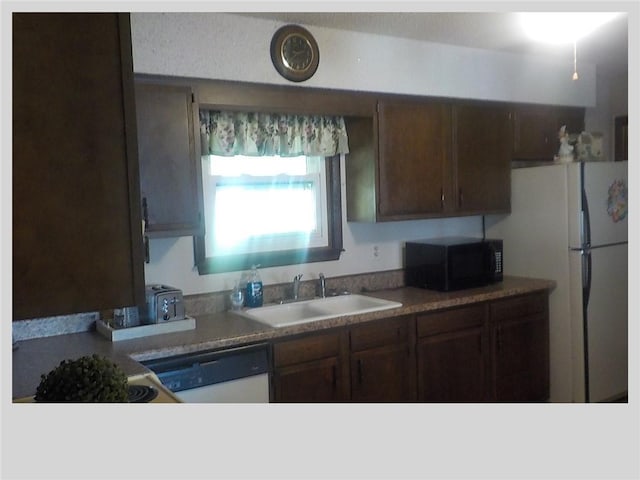 kitchen featuring dark brown cabinets, sink, and white appliances