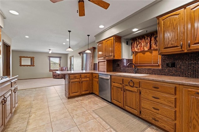 kitchen featuring sink, decorative light fixtures, stainless steel dishwasher, kitchen peninsula, and decorative backsplash