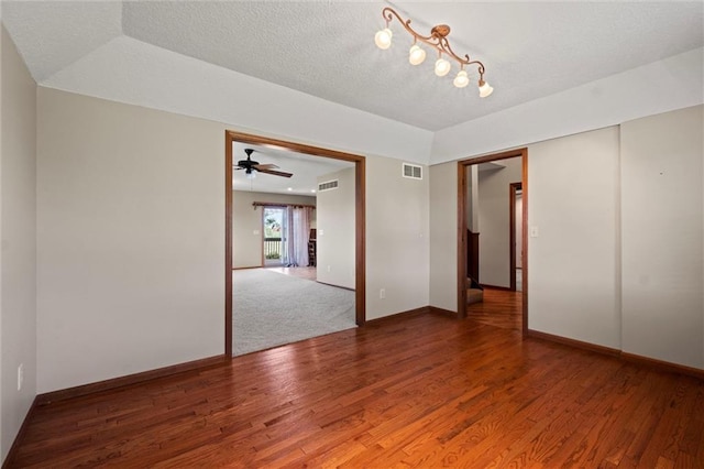 empty room featuring wood-type flooring and a tray ceiling