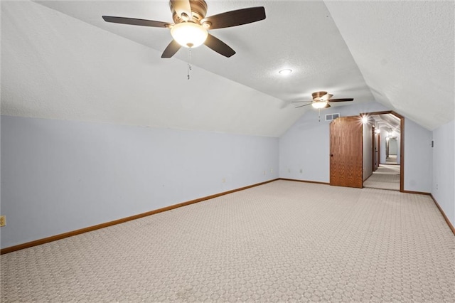 bonus room with vaulted ceiling and light carpet