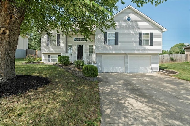 split foyer home featuring a garage, fence, a front lawn, and concrete driveway