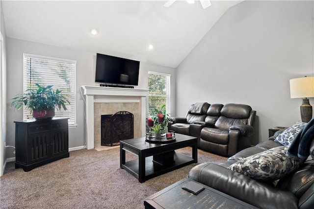 living room with carpet, vaulted ceiling, a tiled fireplace, and ceiling fan