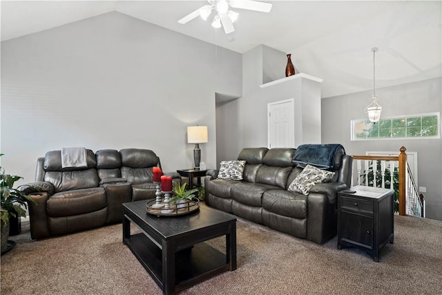 carpeted living room with ceiling fan and high vaulted ceiling