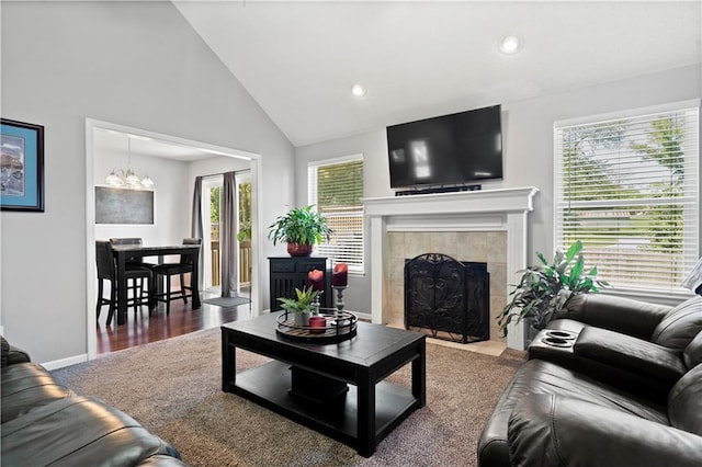 living room with baseboards, a tiled fireplace, dark wood-type flooring, a notable chandelier, and recessed lighting