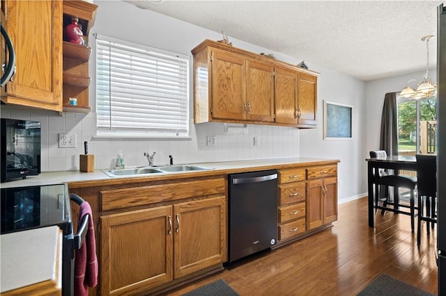 kitchen with brown cabinetry, dishwasher, light countertops, pendant lighting, and a sink