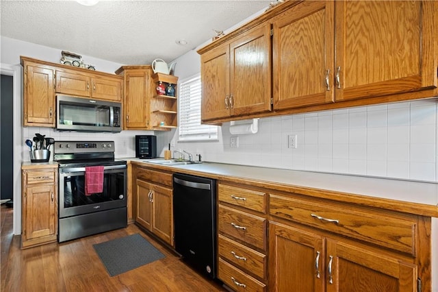 kitchen with a sink, stainless steel appliances, brown cabinetry, and light countertops