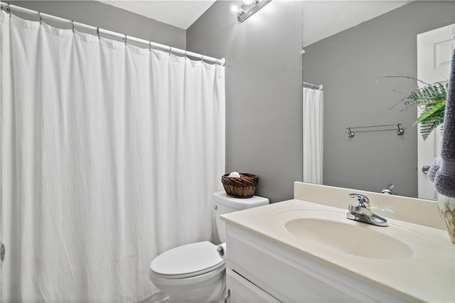 bathroom featuring vanity, toilet, and a textured ceiling