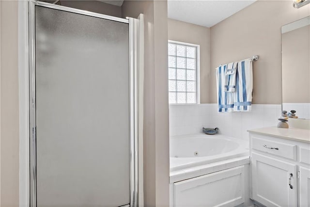 full bathroom with a whirlpool tub, a stall shower, and vanity