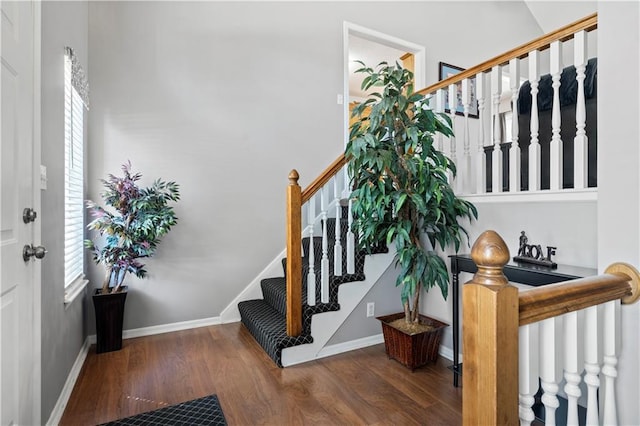 foyer with stairs, dark wood-style flooring, plenty of natural light, and baseboards