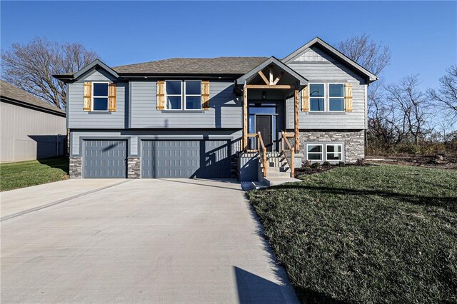 bi-level home with a garage and a front lawn