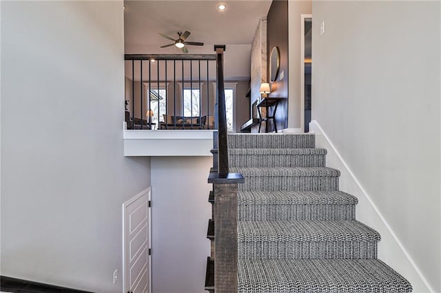 staircase featuring ceiling fan