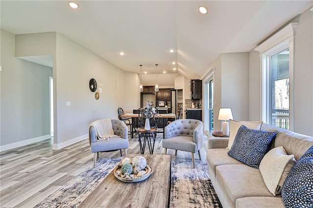 living room featuring vaulted ceiling and light hardwood / wood-style flooring