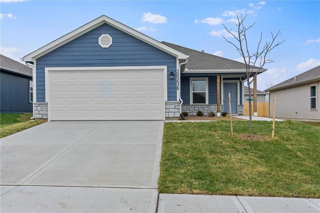 single story home featuring a garage, stone siding, concrete driveway, and a front yard