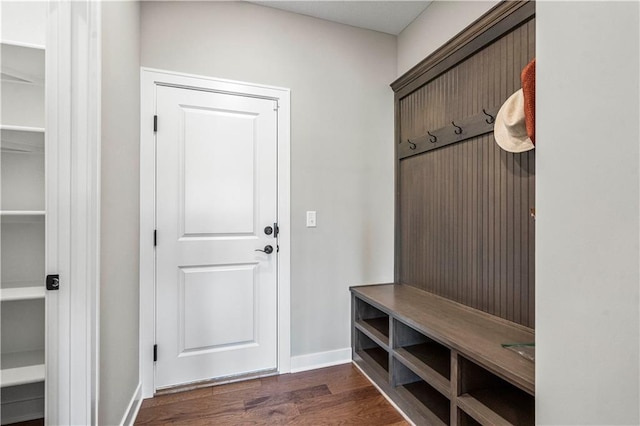 mudroom featuring dark wood-type flooring and baseboards