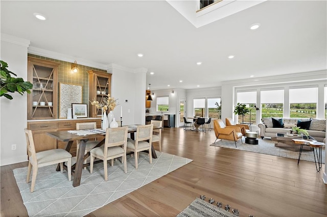 dining area with ornamental molding and light wood-type flooring