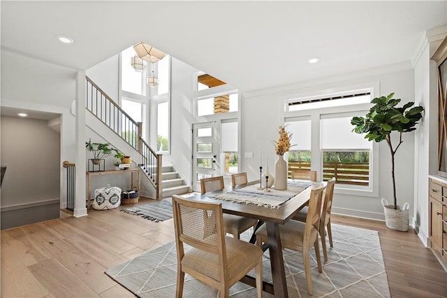 dining room featuring crown molding, light hardwood / wood-style flooring, and a wealth of natural light