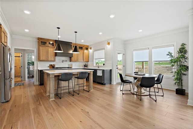 kitchen with premium range hood, pendant lighting, light wood-type flooring, and stainless steel refrigerator