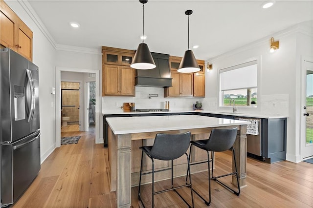 kitchen featuring light wood-type flooring, stainless steel dishwasher, premium range hood, and fridge with ice dispenser