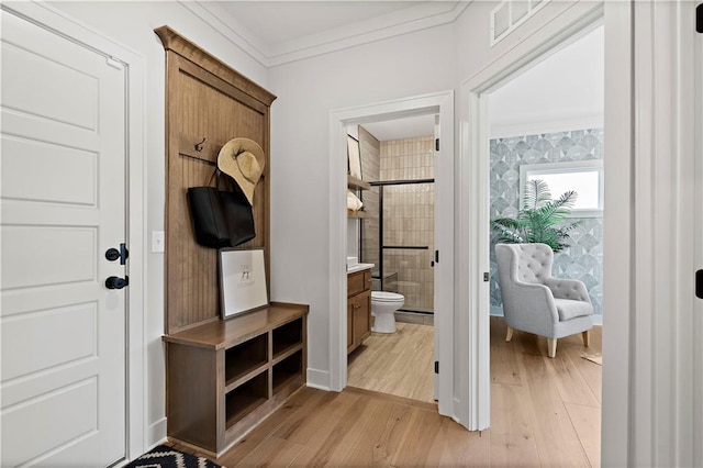 mudroom with crown molding and light hardwood / wood-style floors