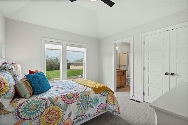 bedroom with ceiling fan, light colored carpet, a closet, vaulted ceiling, and connected bathroom