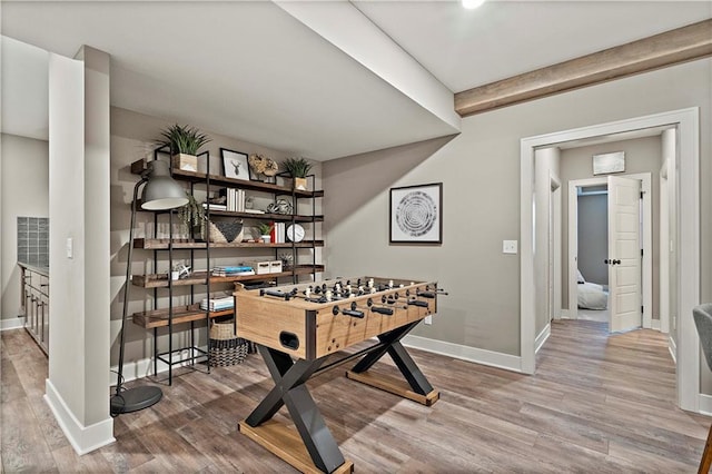 recreation room with beam ceiling and wood-type flooring