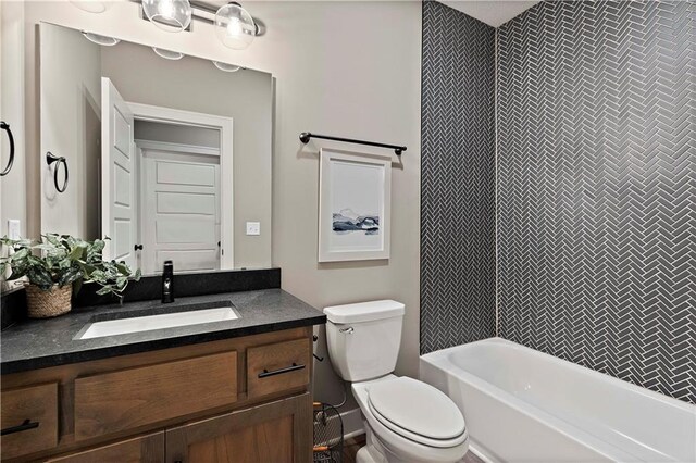 full bathroom with tiled shower / bath combo, toilet, and vanity