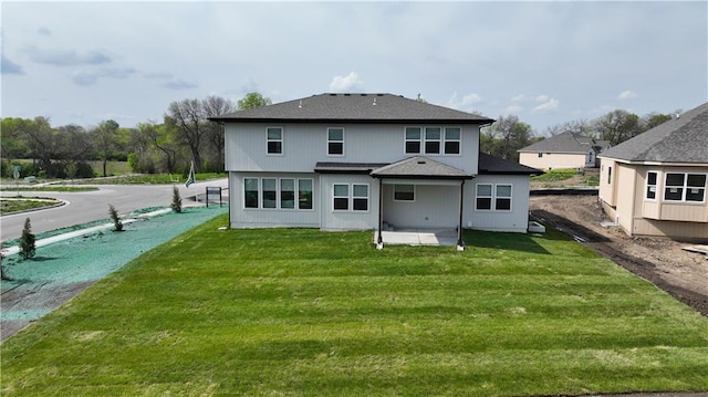 rear view of property featuring a yard and a patio area