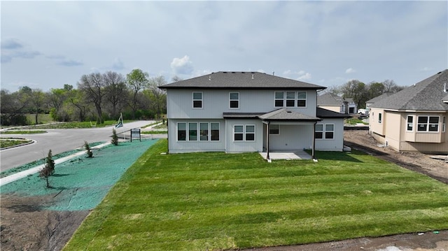 rear view of house with a yard and a patio