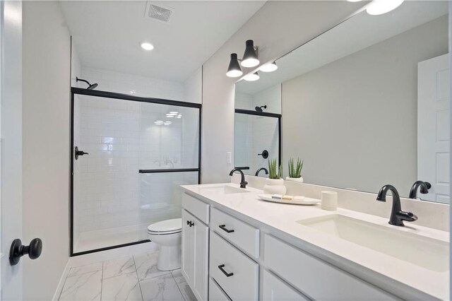 bathroom featuring tile patterned flooring, walk in shower, dual vanity, and toilet