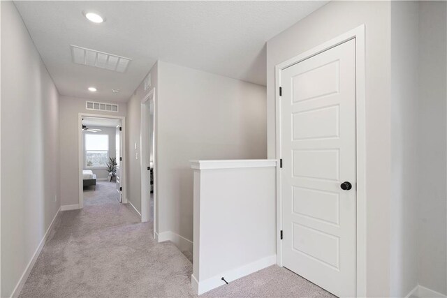 hall featuring light colored carpet