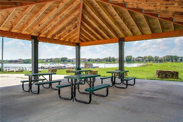 view of property's community with a lawn, a water view, a gazebo, and a patio