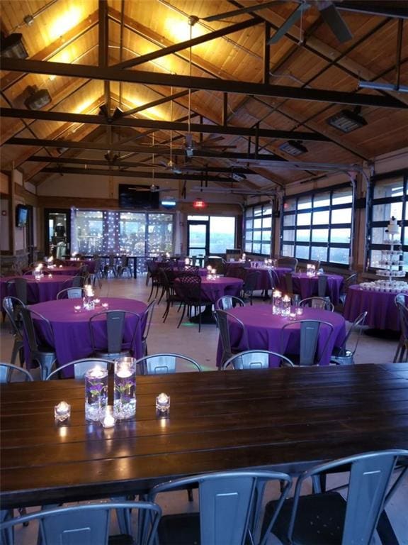 dining area with carpet, high vaulted ceiling, and wooden ceiling