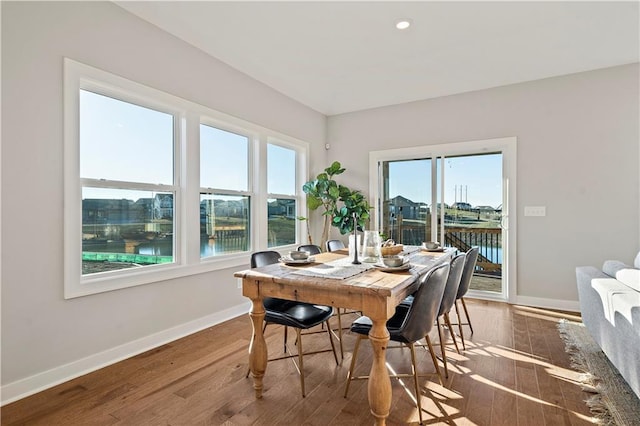 dining room with wood-type flooring and a water view