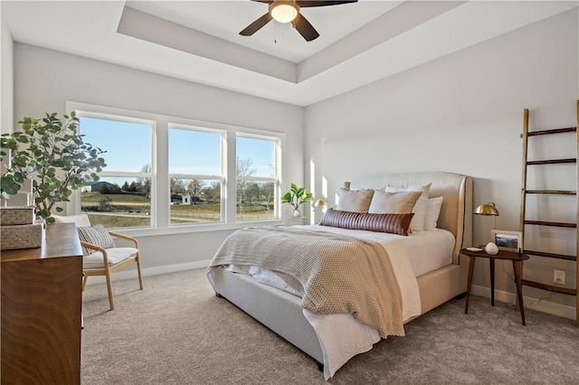 bedroom with a tray ceiling, carpet flooring, and ceiling fan