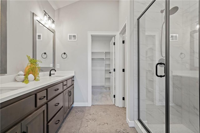 bathroom featuring tile patterned floors, double sink vanity, and a shower with door