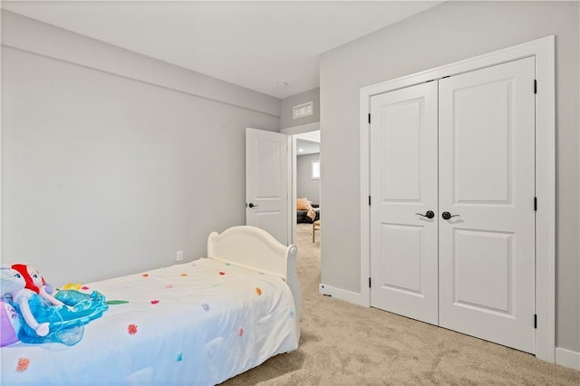 bedroom featuring light colored carpet and a closet