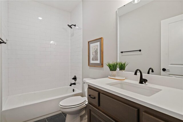 full bathroom with tile patterned floors, tiled shower / bath, vanity, and toilet