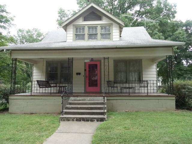 bungalow-style house featuring a front yard and covered porch