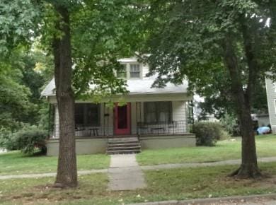 view of front of home with a porch and a front yard