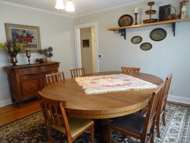 dining space with hardwood / wood-style flooring and ornamental molding