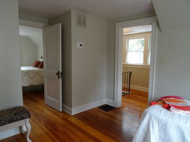 bedroom featuring wood finished floors, visible vents, and baseboards