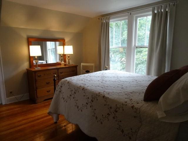 bedroom featuring light wood-style floors and vaulted ceiling