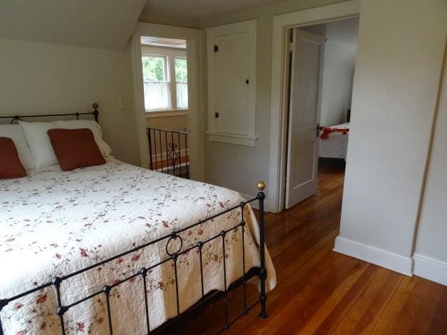 bedroom featuring dark wood-style floors and baseboards