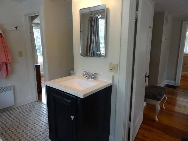 bathroom featuring radiator heating unit, vanity, and wood-type flooring